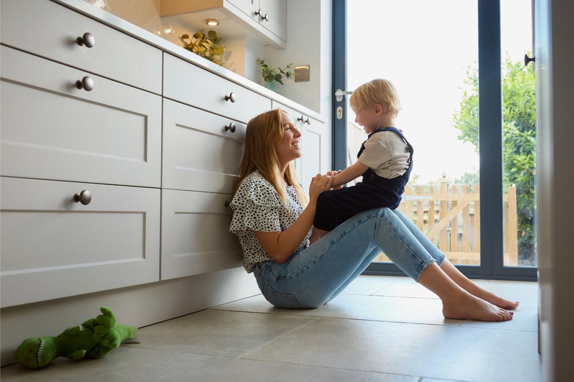 Moeder en kind samen in een keuken, symbolisch voor een veilig thuis met de juiste woonverzekering.