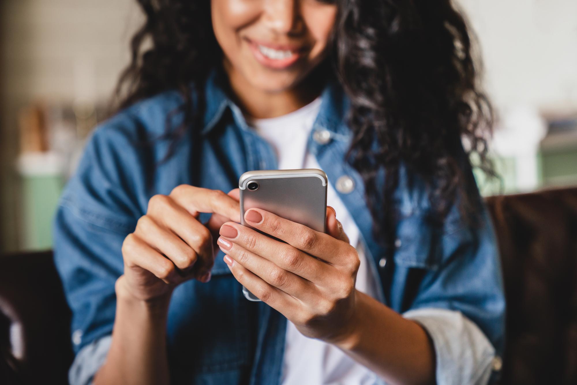 Vrouw gebruikt smartphone, passend bij contactformulier van EVR.