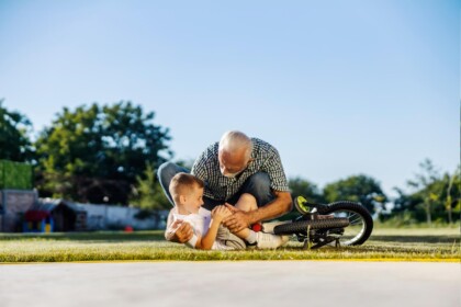 Kind dat net gebotst is met een auto wordt verzorgd door zijn vader, passend bij letselschade bij kinderen.
