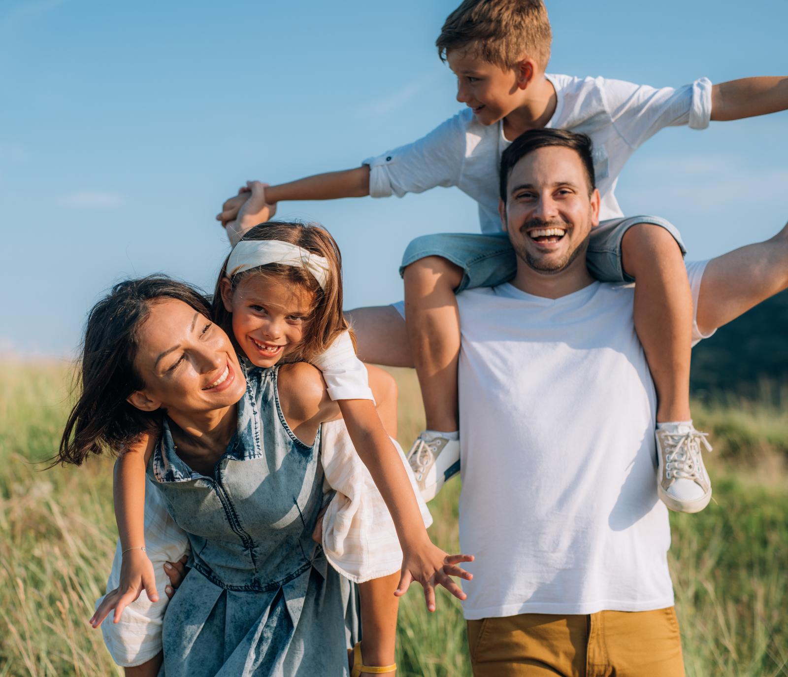 Blije familie in de natuur, symbool voor financiële zekerheid met particulier pensioen.