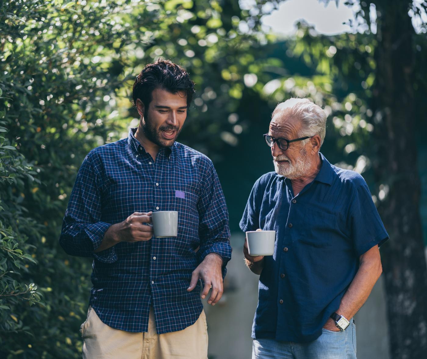 Vader en zoon bespreken onder het genot van koffie de mogelijkheid om garant te staan voor een hypotheek via EVR.