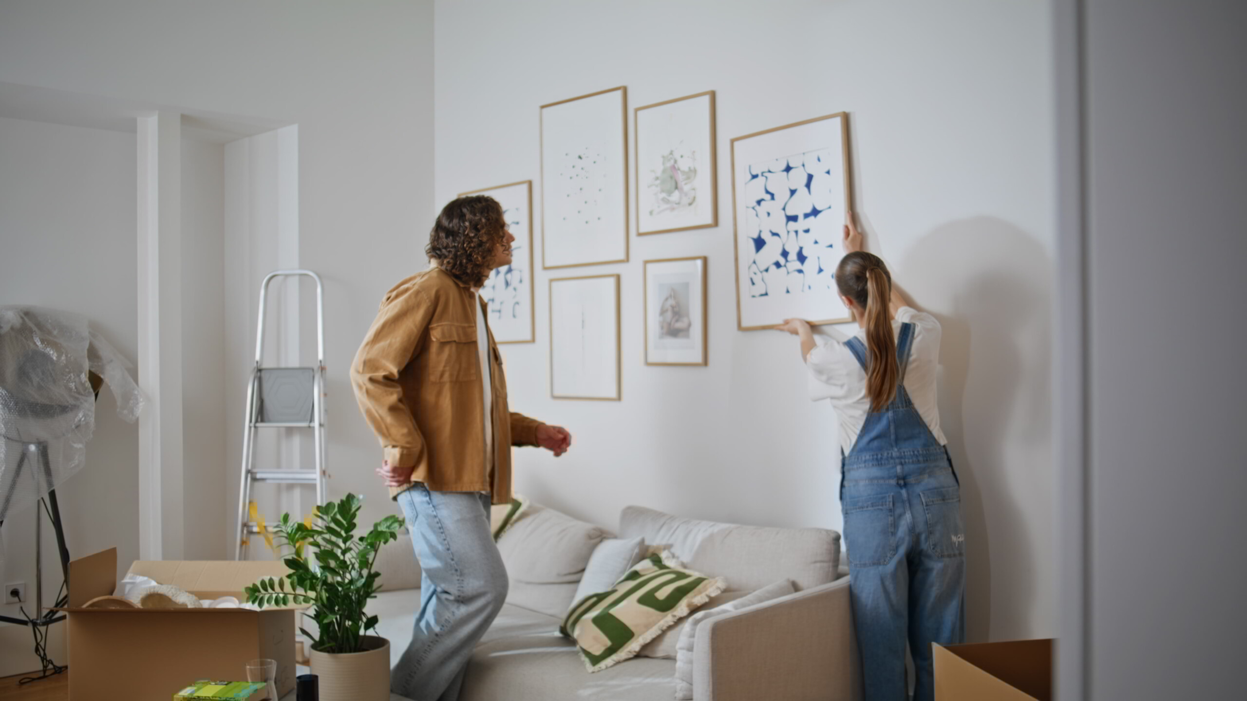 Stel richt samen nieuw interieur in na verhuizing, passend bij thema dalende hypotheekachterstanden.