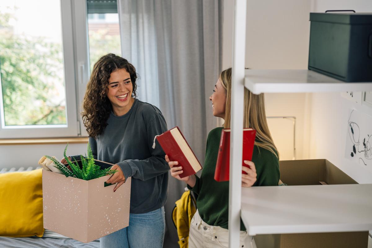 Twee jonge vrouwen regelen samen hun verhuizing en bespreken welke verzekeringen nodig zijn voor hun nieuwe woning.