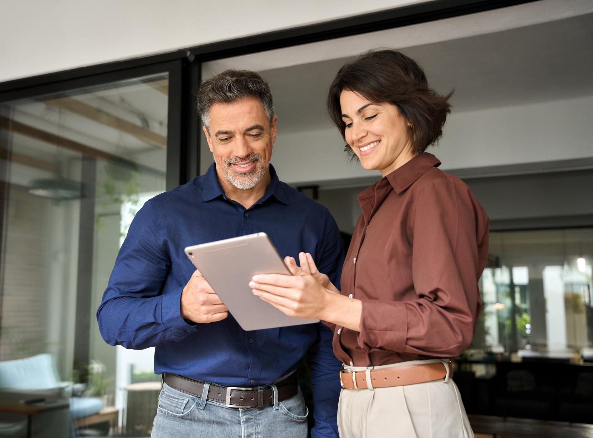 Man en vrouw bekijken samen informatie over garant staan voor een hypotheek op tablet bij EVR.