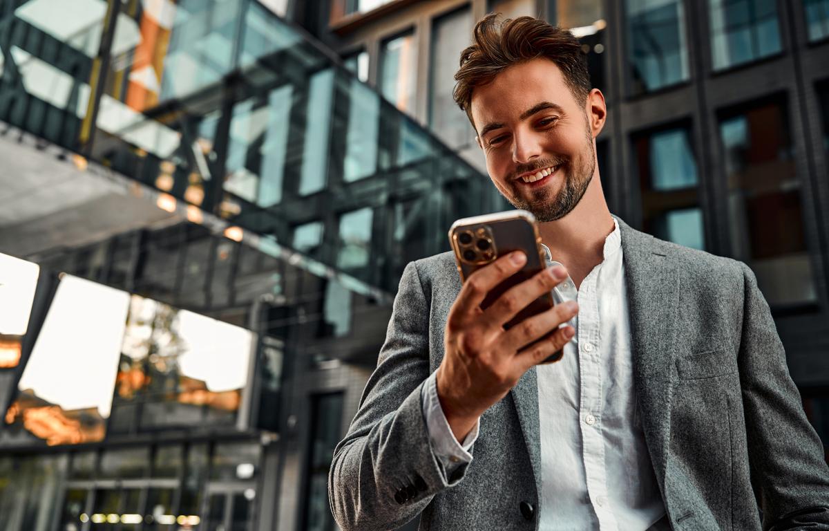 Zelfstandige ondernemer leest op smartphone nieuws over verplichte arbeidsongeschiktheidsverzekering.